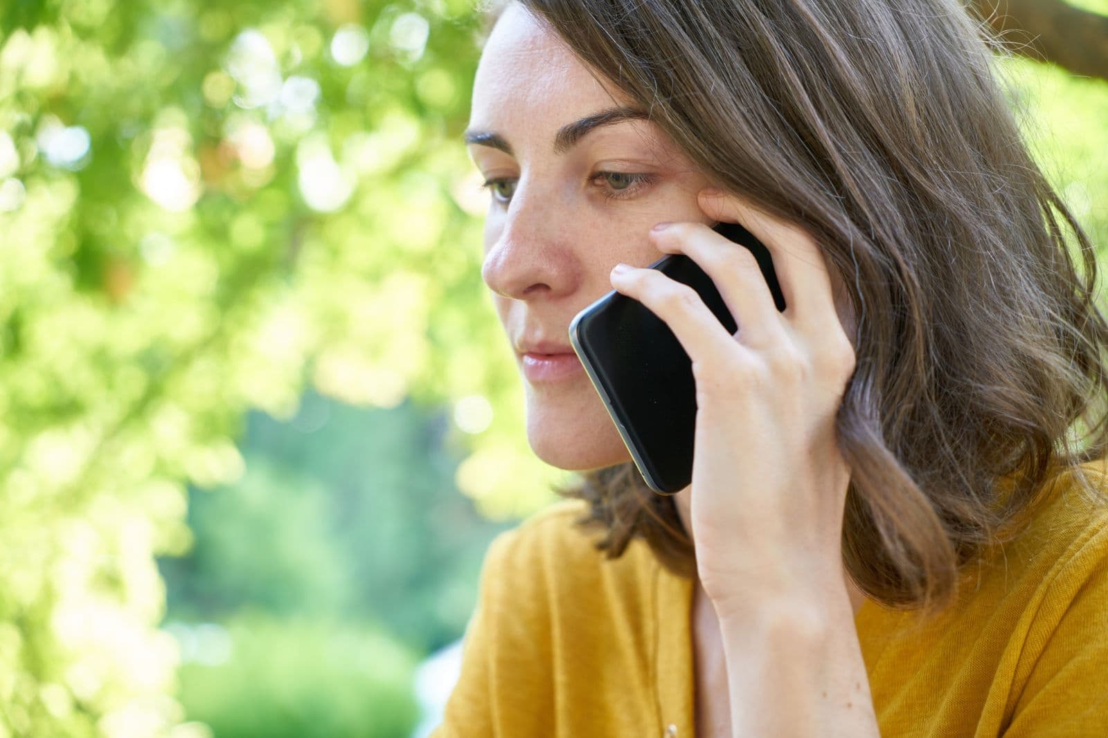 A woman outdoors, writing on her phone