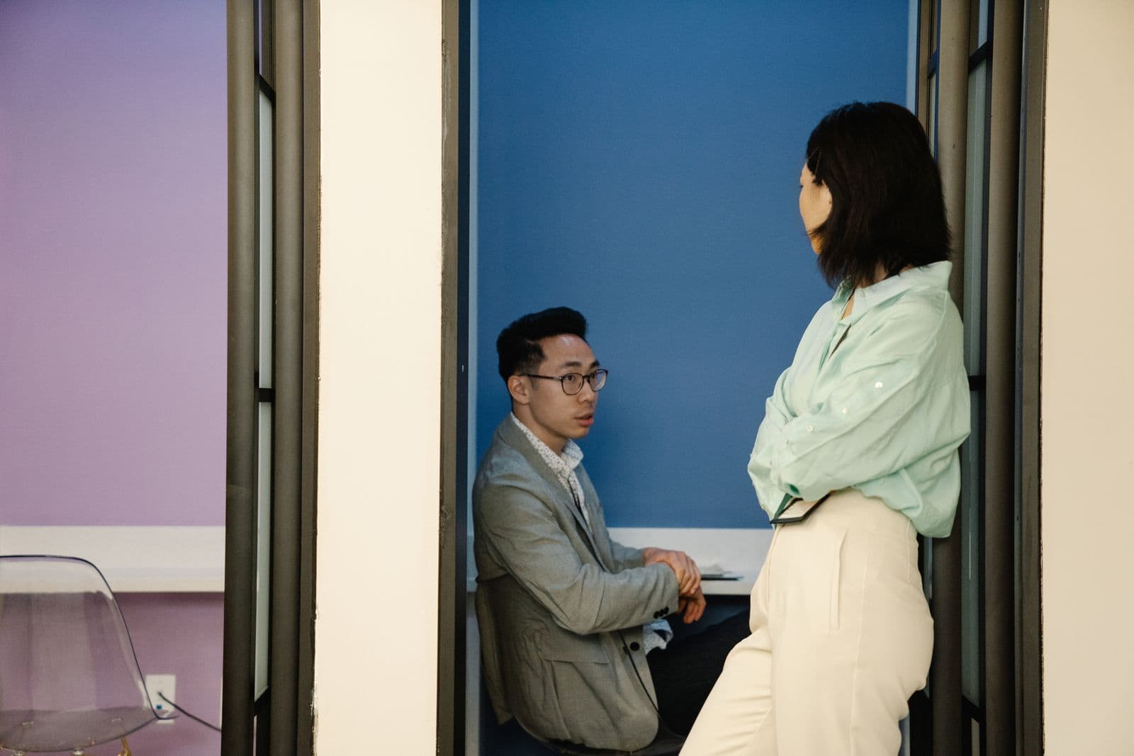 A couple standing by a window, mid-conversation